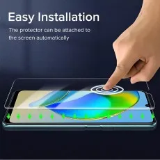 A person installing a screen protector on an Infinix Note 12 smartphone, demonstrating easy automatic attachment with green arrows indicating smooth application