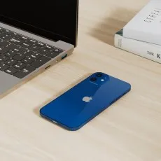 Apple iPhone 12 64GB Unlocked Renewed in Blue, showcasing the back design alongside a laptop