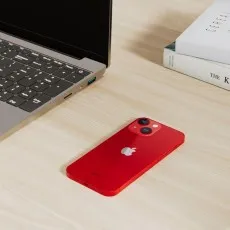 Refurbished Apple iPhone 13 Mini 128GB in red on a desk setting