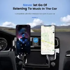 iPhone connected via black aux cable to a car stereo, with one phone displaying music playback and another showing navigation, demonstrating in-car audio compatibility