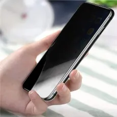 A hand holding a smartphone with a dark screen
