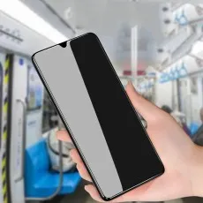 Hand holds a phone with a privacy screen in a public transport setting, showing visible and invisible areas