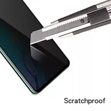 A retractable utility knife blade is being dragged across a phone screen to demonstrate its scratch-proof quality