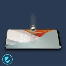 A metallic ball is about to drop onto a smartphone with a screen protector