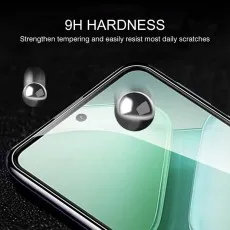 A close-up of a smartphone screen protector with 9H HARDNESS text and metal balls on its surface