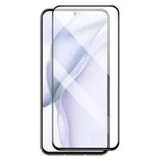 A clear smartphone screen protector standing next to a phone