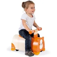 A happy young girl smiling while riding the wooden guinea pig ride-on toy.
