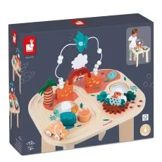The product box for a Janod wooden activity table, showing the dinosaur-themed toy with a bead maze, gears, and a small wooden vehicle.