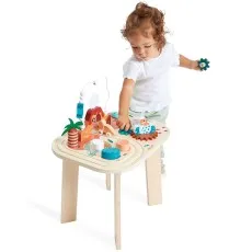 A product lifestyle photo showing a child playing with the Janod wooden activity table.