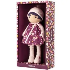 A purple-dressed Kaloo doll with a floral pattern and a pink hat, packaged in a matching box from a slightly different angle