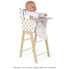 A baby doll sits in a Janod toy high chair with a pink tray, a natural wood frame, and gold polka dot print.