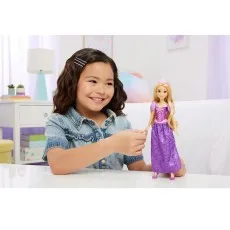 A smiling girl holding the hand of a Disney Princess Rapunzel doll with a purple dress and tiara.