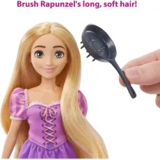 A hand holding a black frying pan hairbrush, about to brush the long, blonde hair of the Rapunzel doll.