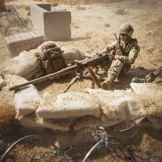 A G.I. Joe Action Soldier figure is positioned behind sandbags, operating a heavy machine gun.
