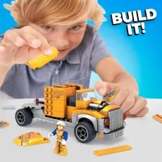 A boy building a Hot Wheels Mega Construx Transporter truck with a figure.