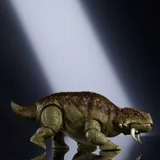 A Jurassic World Hammond Collection Scutosaurus toy, with its mouth open, on a dark, reflective surface.