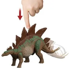 A hand pushes a large brown and green toy stegosaurus's back plate down, causing its spiky tail to swing to the side.