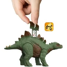 A hand inserts a scannable tab into the back of a green toy stegosaurus.