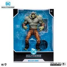 A Killer Croc action figure in a box. The figure has scaly green skin and orange pants