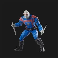 A Drax action figure in a blue and red suit, holding two knives, posed on a black background