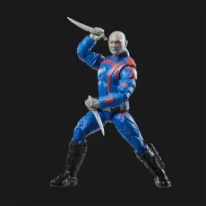 A posed Drax action figure holding two knives on a black background