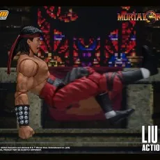 The Liu Kang action figure is in a dynamic flying kick pose, with its body horizontal to the ground.