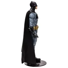 A McFarlane Toys Batman figure from the side, highlighting its textured suit and long black cape.