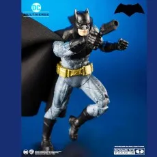A McFarlane Toys DC Multiverse Batman figure in a dynamic pose, holding a large pistol.