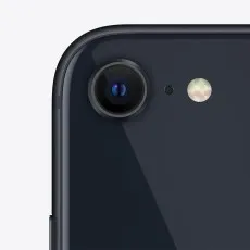 A close-up shot of the single camera lens on the back of a midnight black iPhone SE 3rd Gen.
