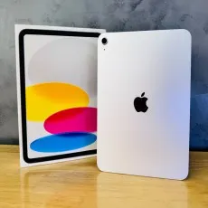 A silver iPad is next to its box on a wooden surface