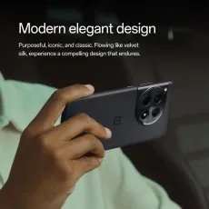 A person's hand holds a black OnePlus 12R, highlighting its design and large camera module.