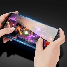 A phone held horizontally, displaying a game with bright graphics, highlighting the screen protector