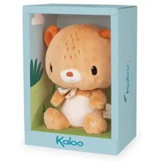 A fluffy brown and white teddy bear with a patterned bow sits in a light blue display box