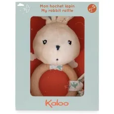 A beige plush rabbit rattle with a wooden ring, packaged in a light blue box with a clear window