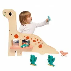 A toddler places a small blue toy car on top of a wooden brontosaurus toy with a slide.