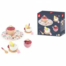 A Janod wooden tea set, including a teapot, teacups with lemon slices, and cookies, next to its box.
