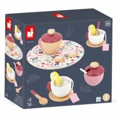 A wooden toy tea set on a floral-patterned mat next to a product box.