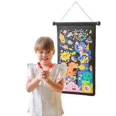 A young girl with a ponytail holds a yellow dart, aiming at a hanging superhero-themed target.