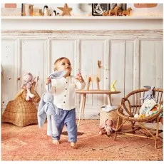 A young child holds a long-eared blue plush rabbit, looking upward with a curious expression.