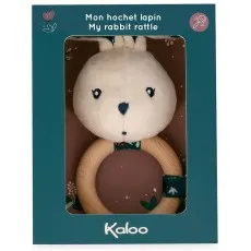 A Kaloo plush rabbit rattle with a wooden ring, in a dark teal and brown box