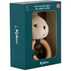 A white plush rabbit rattle with a wooden ring, packaged in a dark teal box