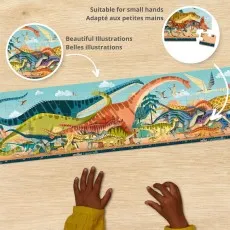 A child's hands assembling a long, horizontal puzzle with a variety of dinosaurs and a measuring tape-like scale at the bottom