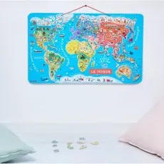 A colorful world map puzzle hanging on a white wall, with loose pieces below it.