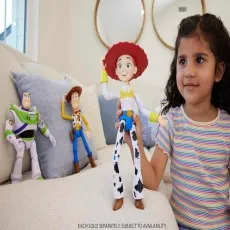 A smiling child is holding a Jessie action figure. A Buzz Lightyear and Woody figure are in the background on a sofa