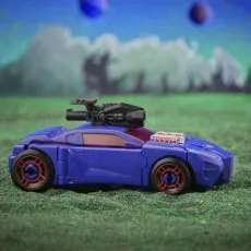 A purple sports car Transformers action figure on a grassy surface