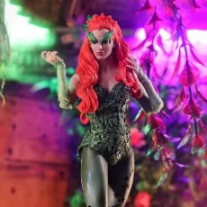 A close-up of a Poison Ivy action figure in a dimly lit, plant-filled setting.