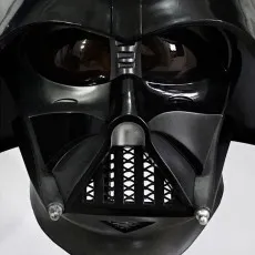 A close-up frontal view of a Star Wars Darth Vader helmet on a display stand.