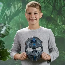 A smiling boy in a gray shirt, holding a Transformers Optimus Primal gorilla mask.