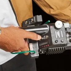 A close-up of a person's hand adjusting a switch on a Ghostbusters Proton Pack wand