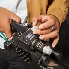 A close-up of a person's hands adjusting a knob on a Ghostbusters Proton Pack wand